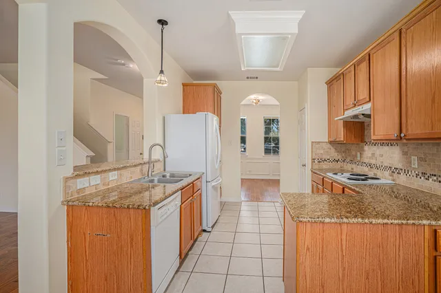 a kitchen with stainless steel appliances granite countertop a sink and a refrigerator