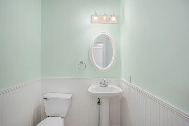 a bathroom with a toilet sink and mirror