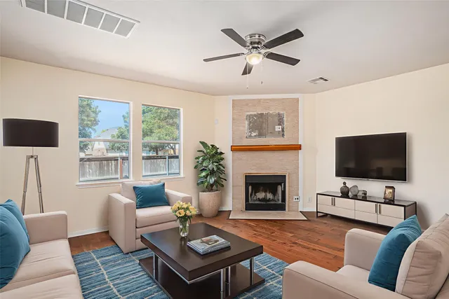 a living room with furniture a flat screen tv and a fireplace
