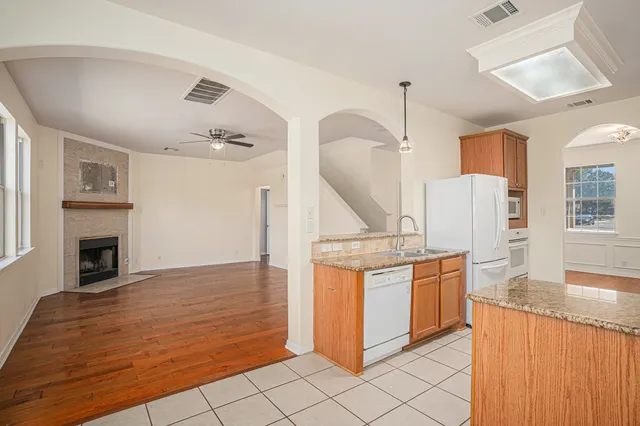 a kitchen with stainless steel appliances granite countertop a stove a sink and a refrigerator