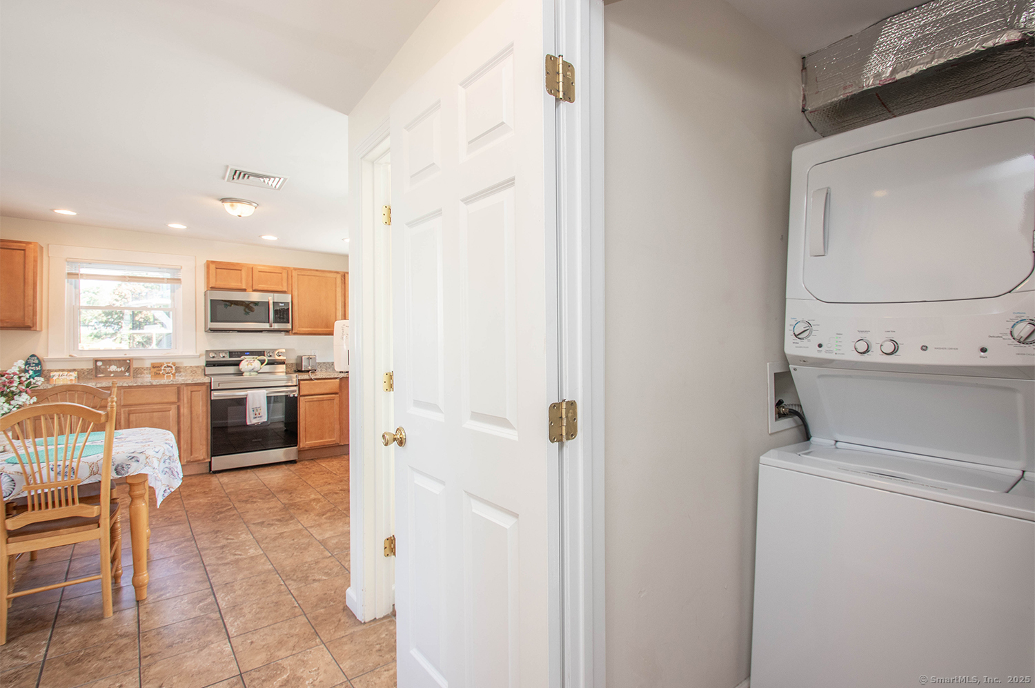 85 Melba Street, Unit 1 Milford, CT 06460 - Photo 12 of 14 a kitchen with a refrigerator and white cabinets
