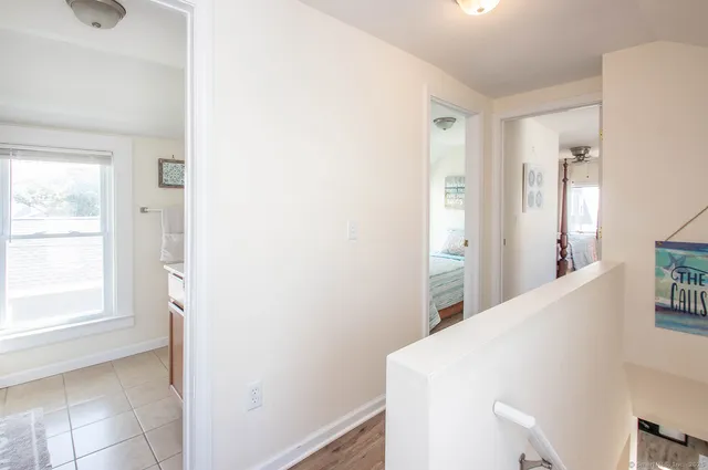 a view of hallway with window and wooden floor