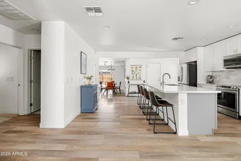 a dining room with kitchen island and stainless steel appliances