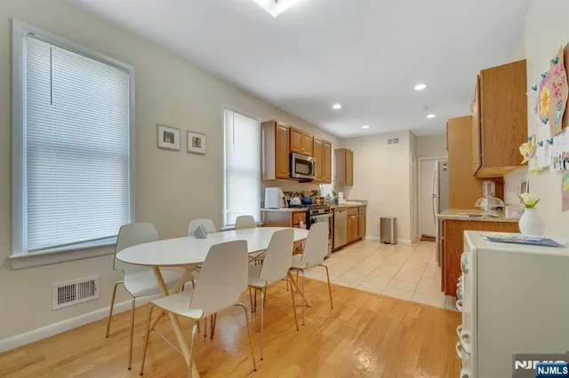 a living room with furniture and a dining table with wooden floor