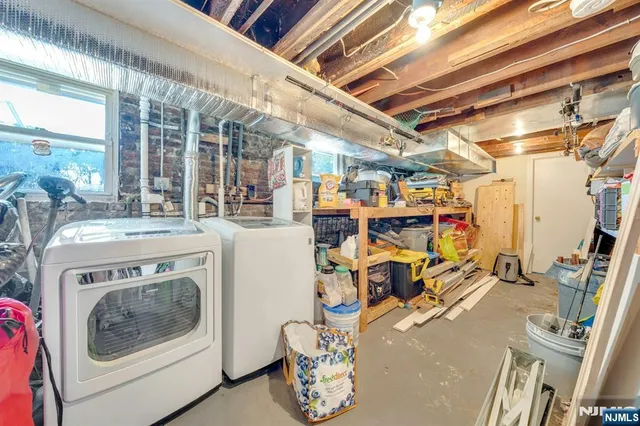 a utility room with dryer washer and a view of living room
