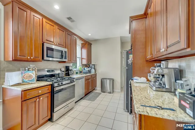 a kitchen with stainless steel appliances granite countertop a stove sink and cabinets