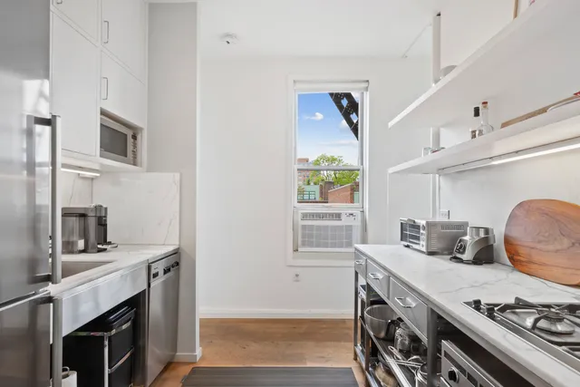 a kitchen with stainless steel appliances a stove a sink and a microwave