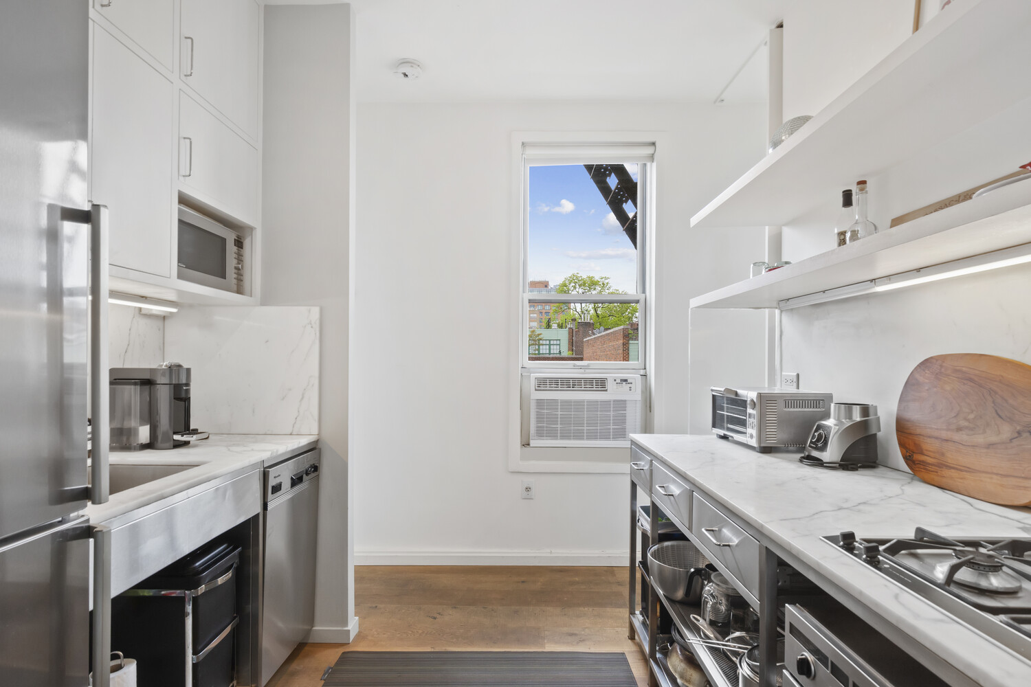 10 Bethune Street, Unit 4A Manhattan, NY 10014 - Photo 4 of 8 a kitchen with stainless steel appliances a stove a sink and a microwave