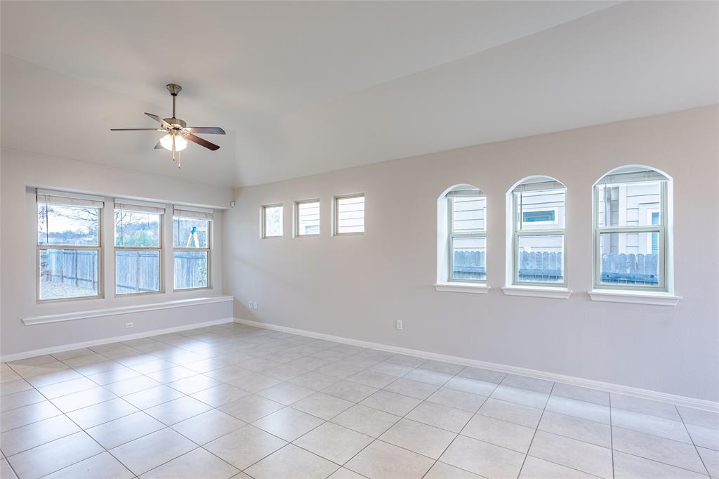 615 Stampede Road San Marcos, TX 78666 - Photo 18 of 26 A spacious room features soaring vaulted ceilings, elegant arched windows, and durable tiled flooring.