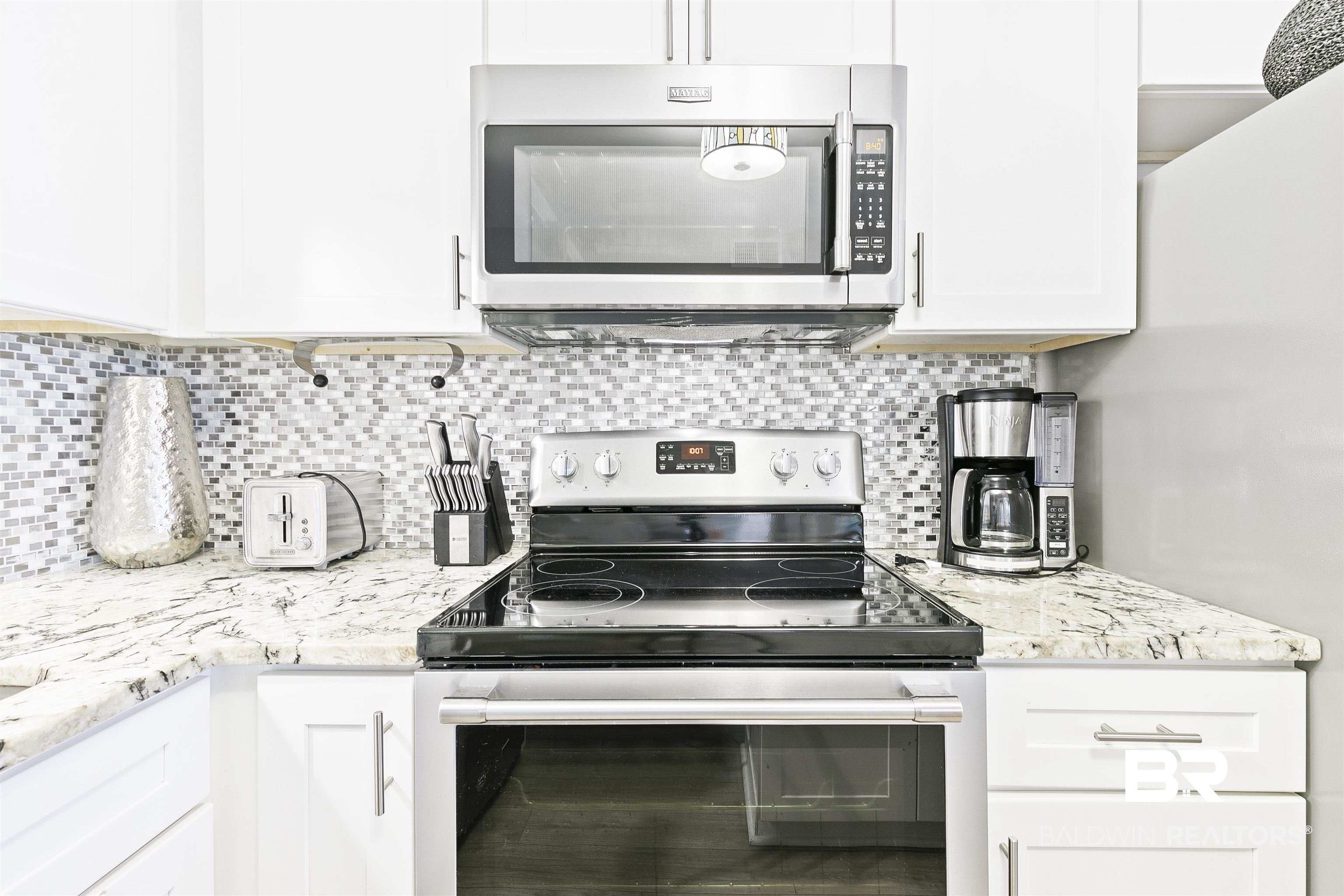 400 Plantation Road, Unit 3314 Gulf Shores, AL 36542 - Photo 14 of 47 Kitchen with light stone countertops, appliances with stainless steel finishes, tasteful backsplash, and white cabinetry