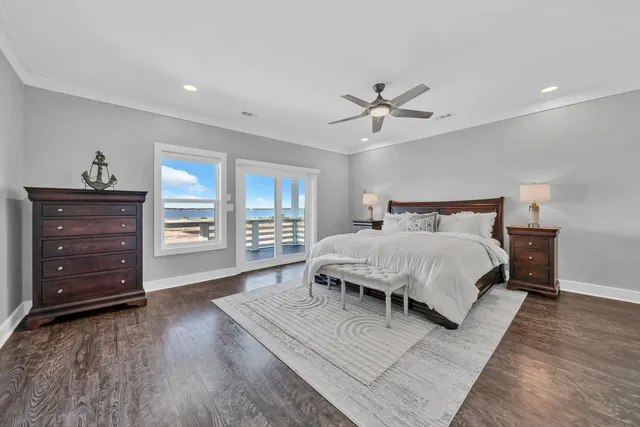 a spacious bedroom with a bed a dresser and a chandelier