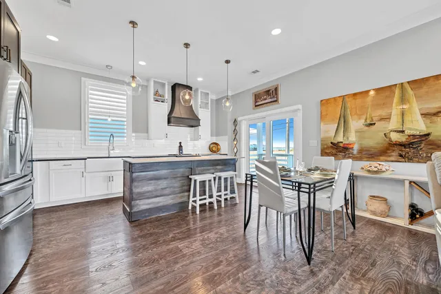 a kitchen with kitchen island a large counter space a sink appliances and a large window
