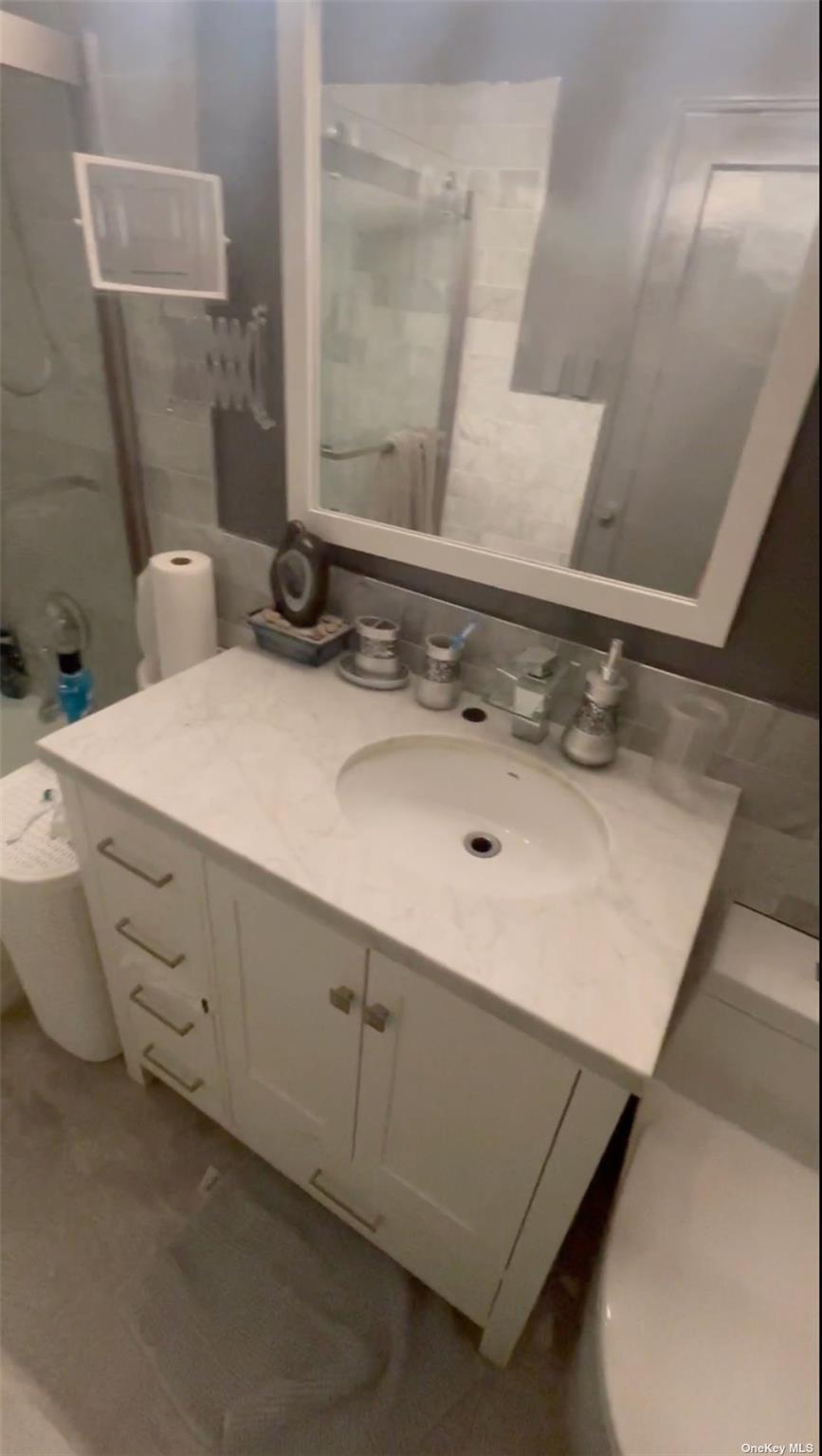 55 Tulip Avenue, Unit 63 Floral Park, NY 11001 - Photo 6 of 7 a bathroom with a sink and a mirror