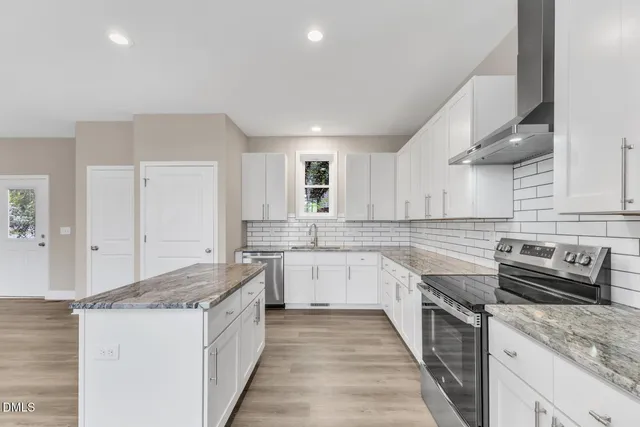 a kitchen with a stove sink and cabinets