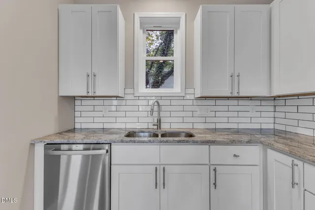 a kitchen with stainless steel appliances granite countertop white cabinets and a stove