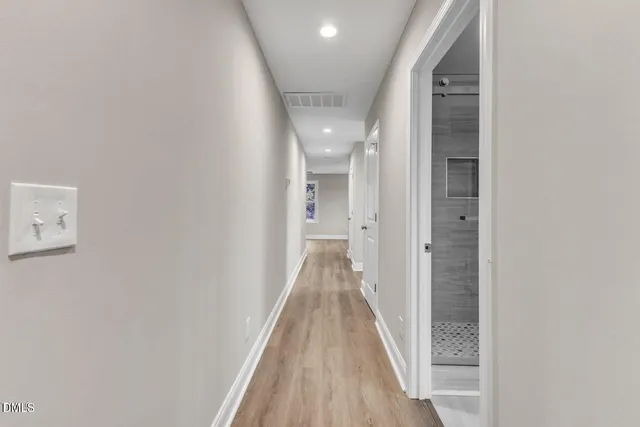 a view of a hallway with wooden floor