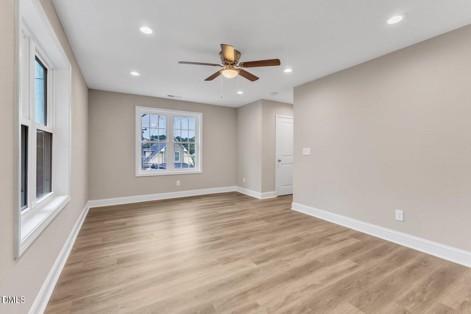 1521 Chapel Hill Road Durham, NC 27701 - Photo 24 of 42 an empty room with wooden floor a ceiling fan and windows