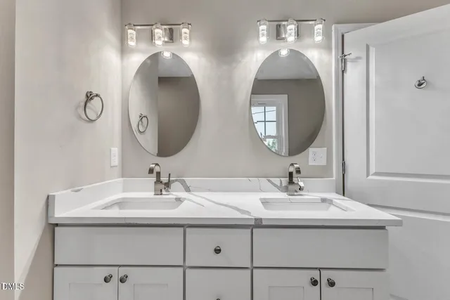 a bathroom with double vanity sinks and a mirror