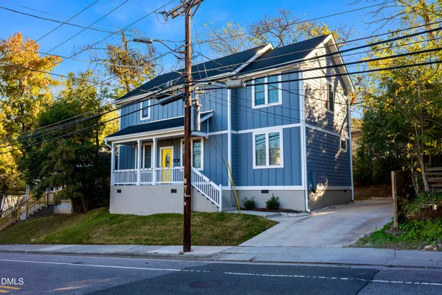 a view of a white house with a yard and plants