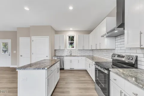 a kitchen with a stove sink and cabinets