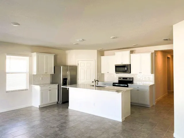 a kitchen with stainless steel appliances a refrigerator sink and microwave