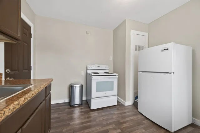 a kitchen with a refrigerator sink stove and cabinets