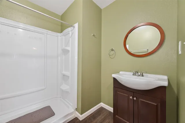 a bathroom with a sink a mirror and a shower