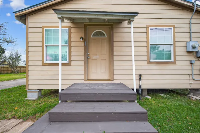 a view of a house with a small yard and wooden floor and fence