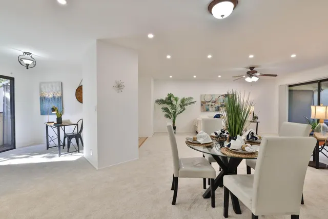 a dining room with furniture and a potted plant
