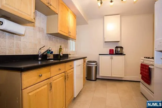 a kitchen with granite countertop a sink a stove and cabinets