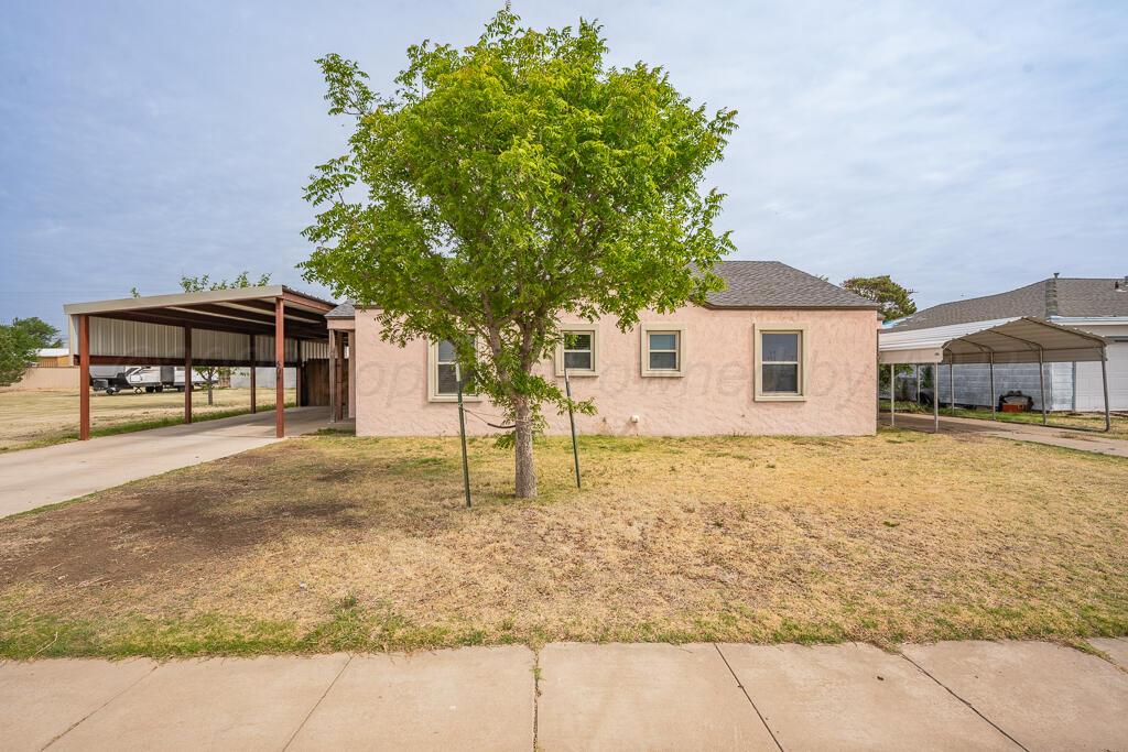 504 East 5th Street Sunray, TX 79086 - Photo 1 of 22 a house with trees in the background