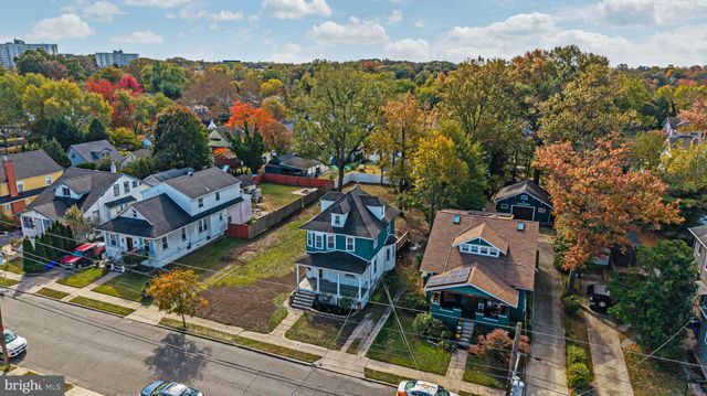 an aerial view of residential houses with outdoor space and trees