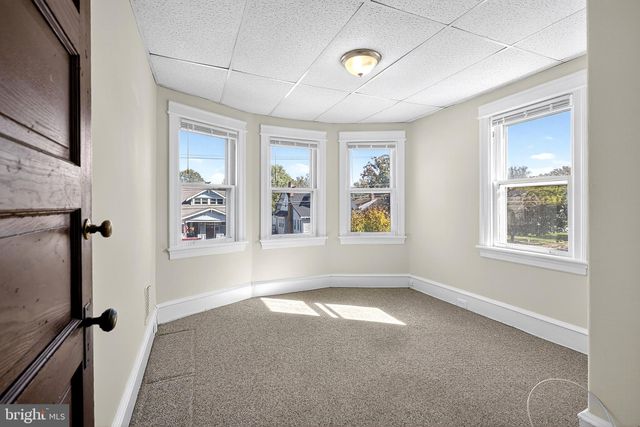 a view of an empty room with wooden and a window