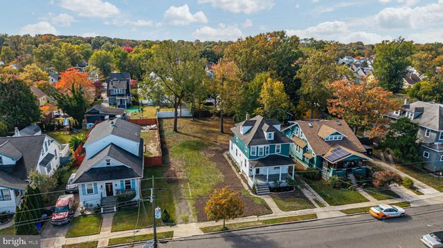 an aerial view of a residential apartment building with a yard and parking spaces