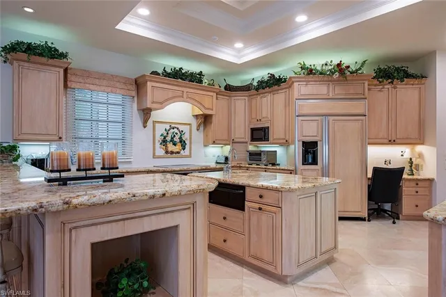 a kitchen with kitchen island granite countertop a stove refrigerator and a sink