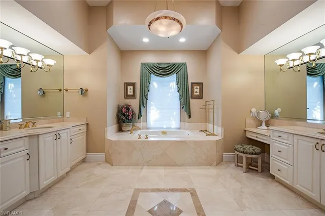 a spacious bathroom with a tub sink and mirror