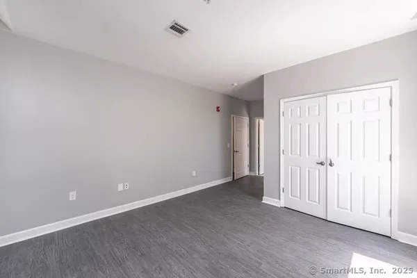 a view of an empty room with wooden floor