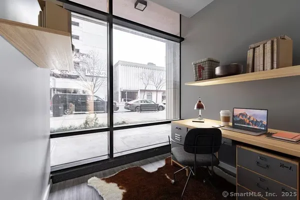 a view of a workspace with furniture and a window