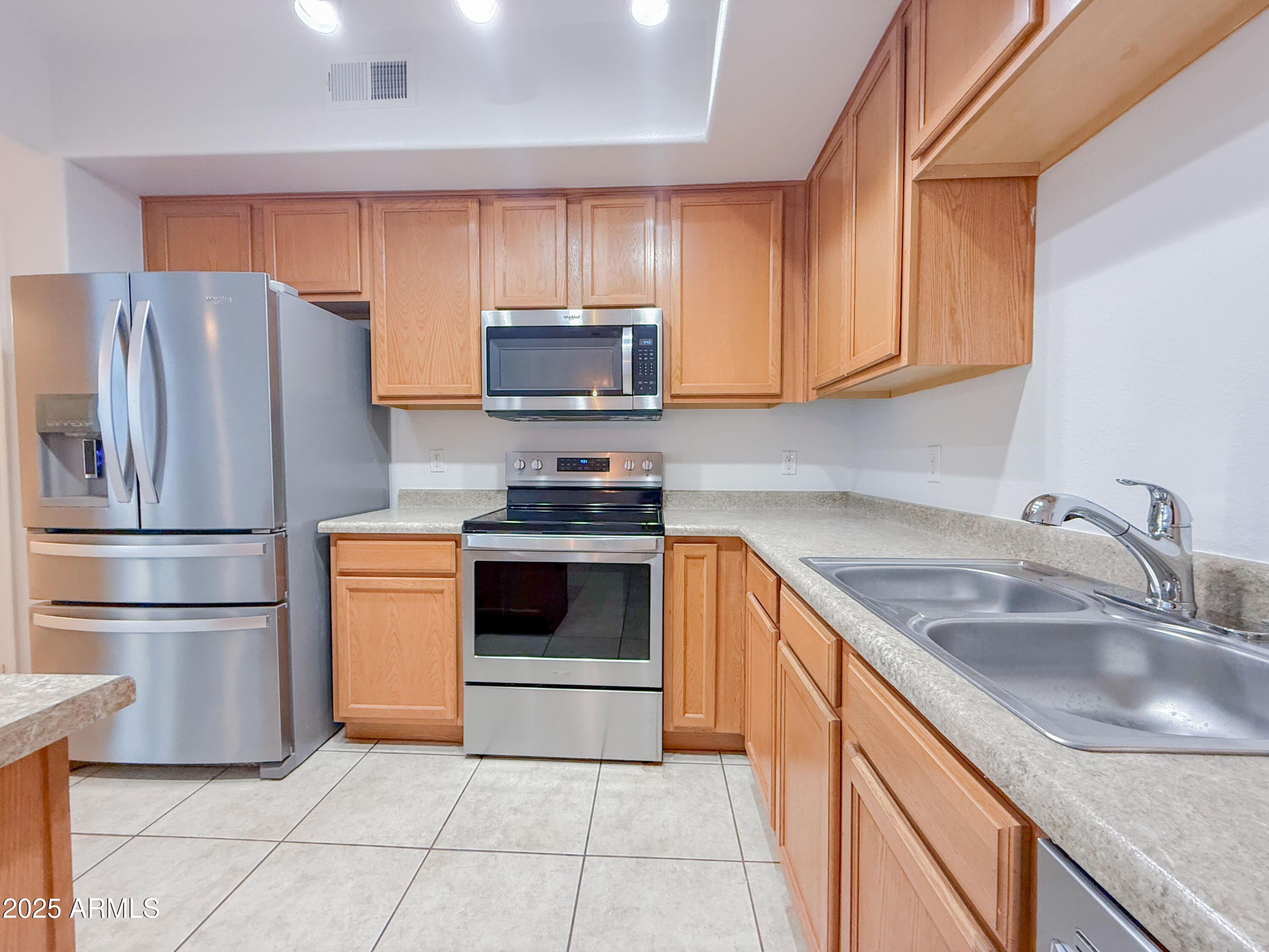 2150 West Alameda Road, Unit 1390 Phoenix, AZ 85085 - Photo 9 of 28 a kitchen with stainless steel appliances granite countertop a refrigerator stove a sink dishwasher and microwave
