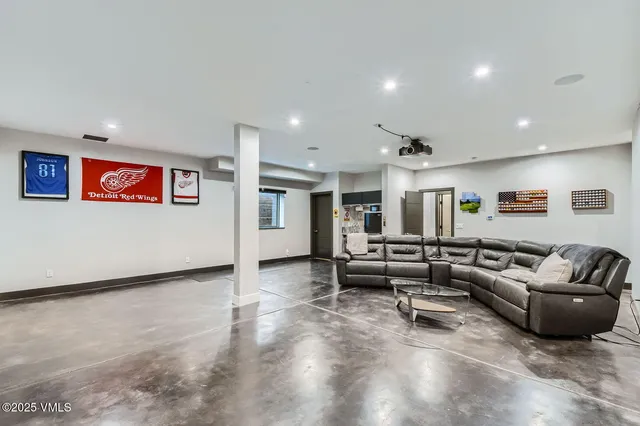 a view of a white house with large windows and lawn chairs