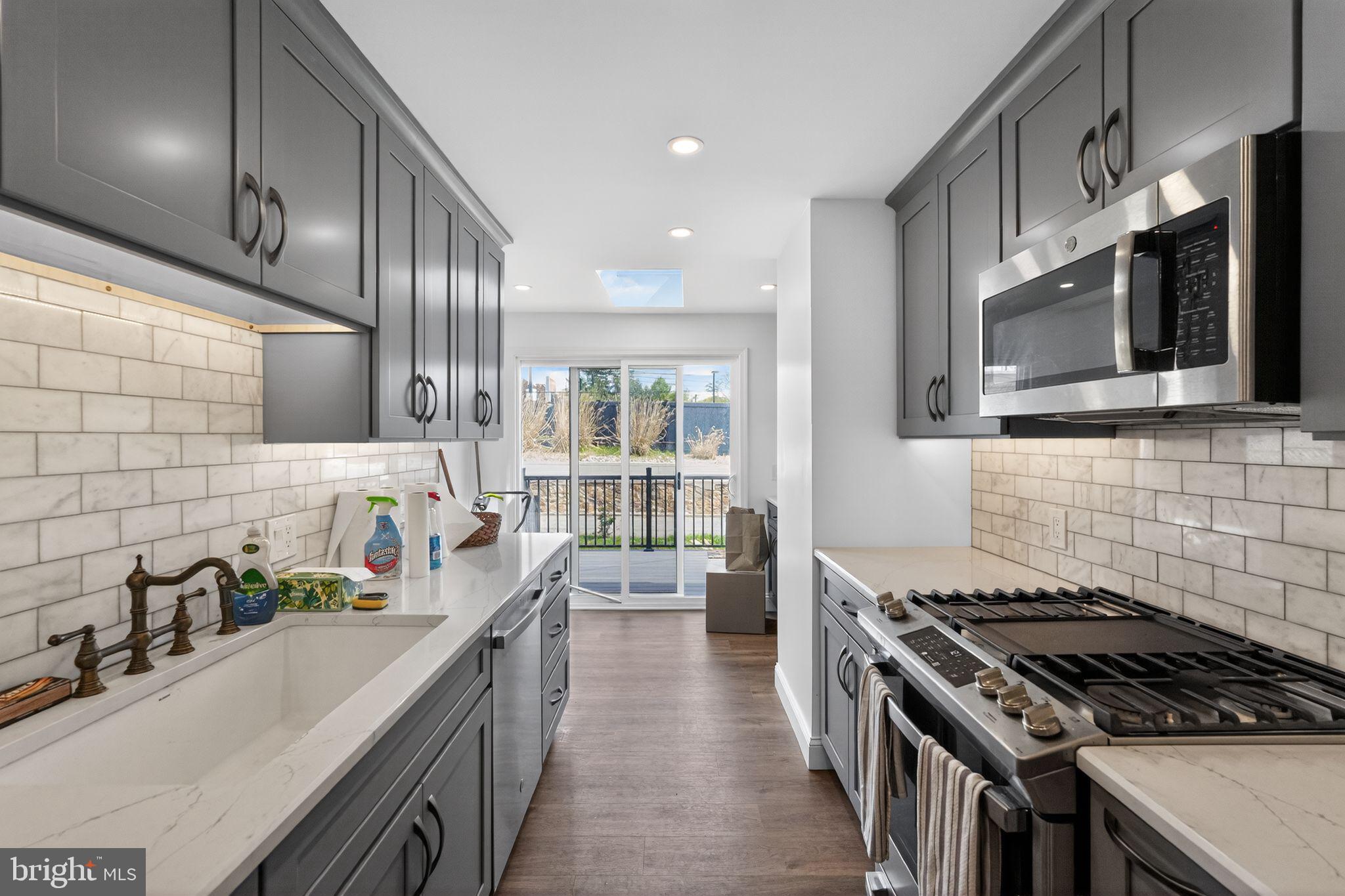 633 Dayton Road Bryn Mawr, PA 19010 - Photo 3 of 18 a kitchen with stainless steel appliances a sink stove and cabinets
