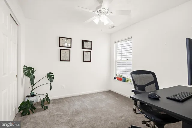 a view of a workspace with furniture and a window
