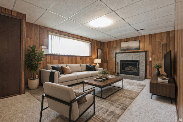 1722 Kimsbrough Road Sandy, UT 84092 - Photo 20 of 29 Living area featuring wood-panel walls, a tile-surround fireplace with a gas insert, and light-colored carpeting