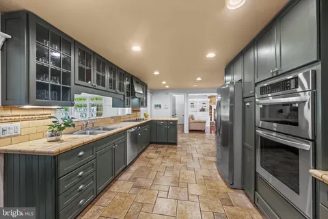 a kitchen with stainless steel appliances granite countertop a sink and a refrigerator