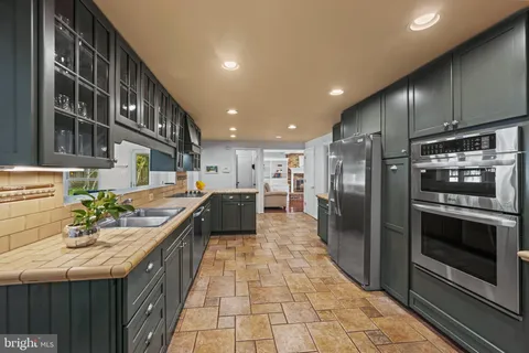 a kitchen with kitchen island a counter top space appliances and cabinets