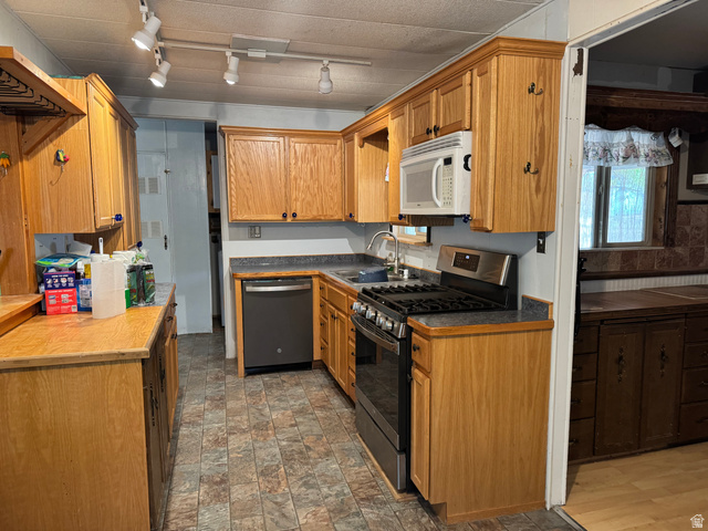 210 South State Street Moroni, UT 84646 - Photo 5 of 23 Kitchen featuring wood-finish cabinetry, track lighting, and a built-in microwave