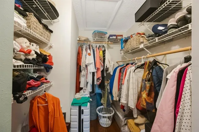 a view of walk in closet with clothes and shoes