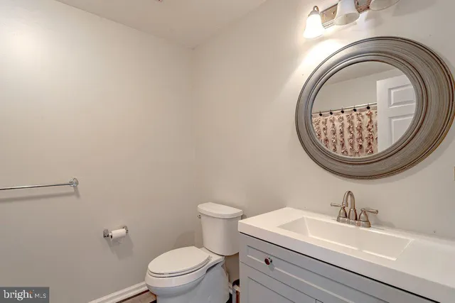 a view of an empty room with wooden floor and windows