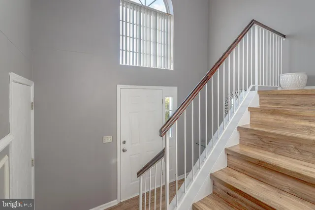 a view of staircase with wooden floor and white walls