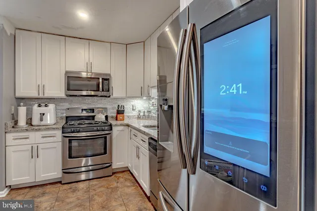 a kitchen with stainless steel appliances granite countertop a stove and a refrigerator